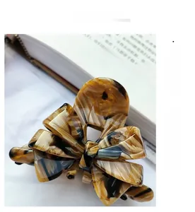 Macro shot of French retro amber tortoiseshell acetate bow hair claw clip on book