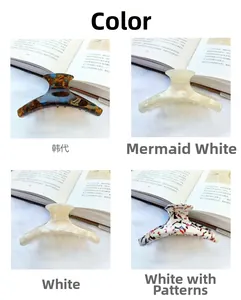 Detail view of four acetate hair claws in tortoiseshell, pearl white, and floral patterns