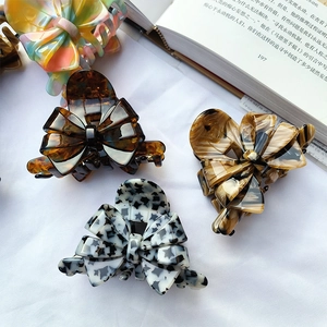 French vintage acetate bow hair claws in tortoiseshell and marble patterns set on fabric