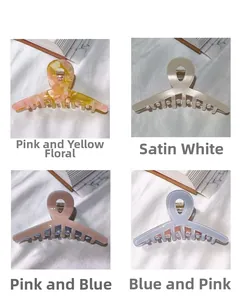 Detail view of four large acetate hair claw clips in floral and gradient patterns