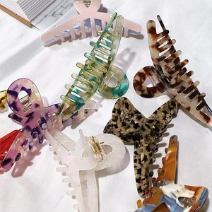 Large acetate hair claws in leopard print and marble patterns for thick hair styling
