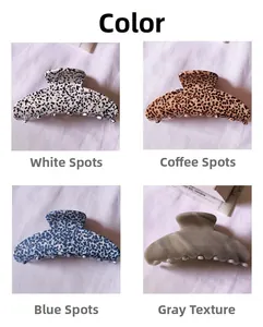 Vue détaillée de quatre pinces à cheveux en acétate en blanc, marron, bleu et texture marbre