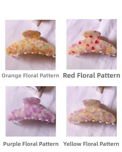 Détail de grandes pinces à cheveux en acétate aux motifs floraux orange, rouge et violet