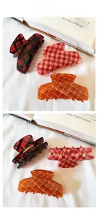 Close-up of vintage plaid pattern acetate hair claws in red and pink colors