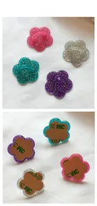 Detailed view of flower phone charms with glitter resin finish and 3M adhesive backing