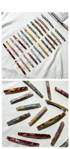 Detailed macro view of various patterns on acetate hair clips with metal spring fasteners