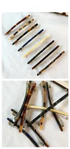 Detail of elegant acetate hair clips with marble patterns and metal spring fasteners