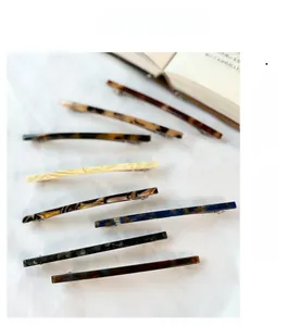 French style acetate hair clips with tortoiseshell and marble patterns on white fabric