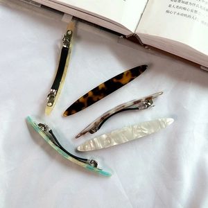 Set of five long acetate leopard print hair clips displayed on a white fabric background