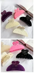 Detailed close-up of crystal bow claw clips on fabric background with tile display