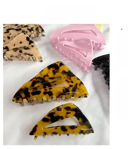 Pinces à cheveux triangulaires ajourées en écaille et couleurs unies sur tissu blanc