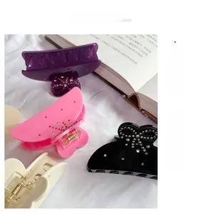Detail of French acetate bow hair claws with sparkling rhinestones in assorted colors