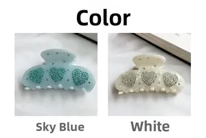 Détail de pinces à cheveux en forme de cœur bleu clair et blanc avec des strass
