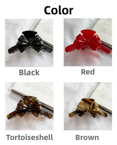 Detail view of large acetate bow hair clips in black, red, and tortoiseshell patterns