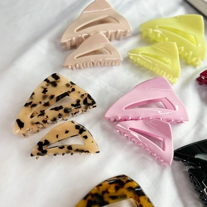 Pince à cheveux triangle en acétate français, couleurs variées sur tissu blanc