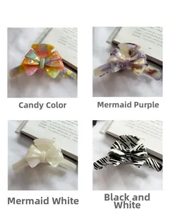 Macro display of French acetate bow hair claws in marble, pearl white and zebra patterns