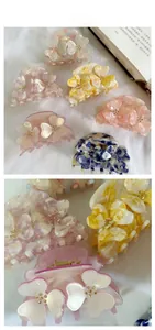 Detail view of floral acetate hair claws with marble texture and pearl stamen center
