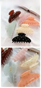Close-up of large acetate hair claw clips with colorful rhinestones and metal spring