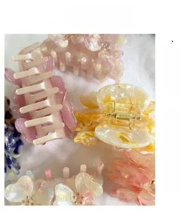 Detail view of acetate flower hair claws with pearlescent finish and metal spring