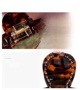 Close-up of tortoise shell resin hair claw clip with rhinestones and gold spring