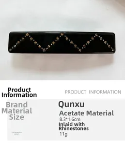 Detail of a black rectangular hair clip with wavy rhinestones on acetate material