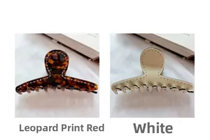 Detail view of large leopard red and cream white acetate hair claws with rhinestones
