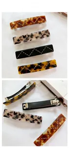 Detail of French hair clips with rhinestones and marble patterns on woven texture