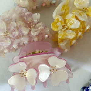 Floral acetate hair claw clips with rhinestones in marble colors on white background