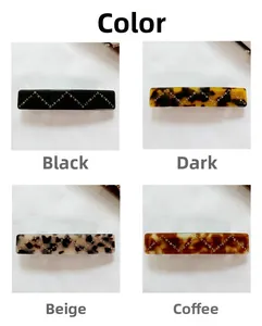 Detail of four acetate hair clips with wavy rhinestone decor in marble and tortoise colors