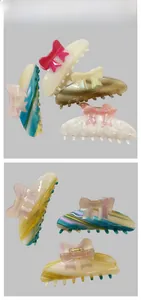 Flat lay of acetate bow hair clips in various colorful patterns and marble finishes
