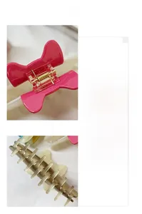Detail view of acetate hair claw with magenta bow showing metal spring and teeth