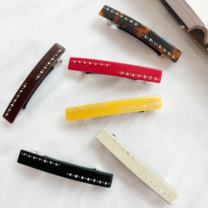 Barrettes à cheveux élégantes avec strass en six couleurs sur fond de tissu blanc