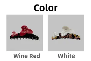 Detail view of wine red and white bow hair claws with sparkling rhinestone centers