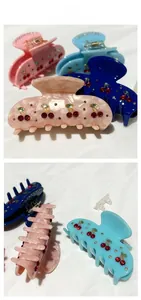 Detailed tile display of cherry rhinestone hair claws in multiple elegant colors