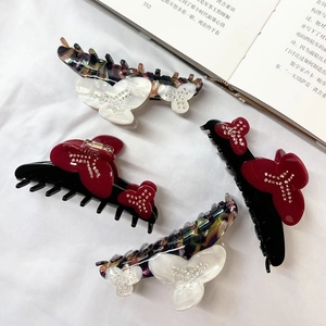 Elegant floral acetate hair claws with butterfly designs and sparkling rhinestones