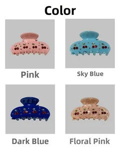 Detail view of cherry rhinestone hair claw clips in pink, sky blue and dark blue colors