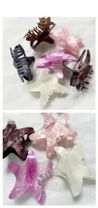 Detailed close-up of pearlescent starfish claw clips with glitter texture and metal springs
