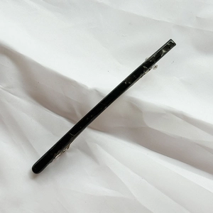 Detail of a large black marble acetate hair clip with silver spring metal fastener