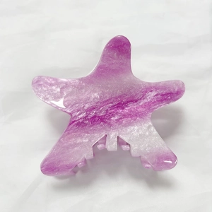 Macro detail of starfish hair claw clip with purple marble pattern and silver glitter finish