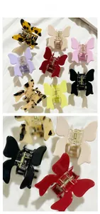 Detail showing various colors of vintage butterfly hair clips on white fabric background