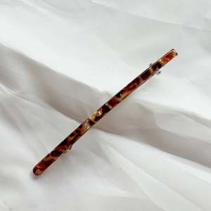 Detailed view of large tortoiseshell acetate hair clip with silver spring metal fastener