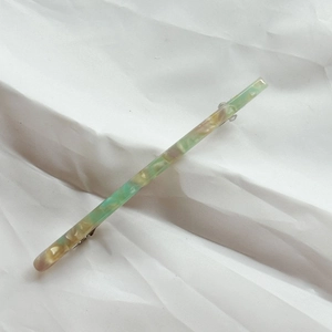 Detail view of large acetate spring clip hair barrette with marble green pattern