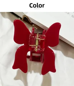 Close-up of a red 3D butterfly hair claw clip with golden metal spring and glossy finish