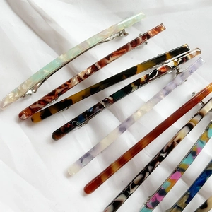 Set of eight minimalist acetate spring hair clips in various marble and floral patterns