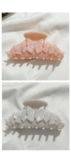 Vue détaillée des pinces à cheveux papillon en acétate avec texture marbrée et strass