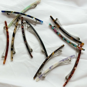 Retro acetate spring hair clips with marble pattern and tortoiseshell finish on white cloth