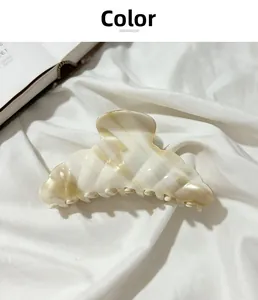 Detail of large acetate croissant hair claw clip with beige marble texture and sturdy grip