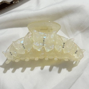 Vue détaillée de la grande pince à cheveux papillon en acétate jaune crème avec strass