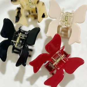 Elegant 3D butterfly hair claws in acetate, available in black, red, cream, and tortoiseshell