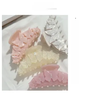 Gros plan sur de grandes pinces à cheveux papillon en acétate avec strass brillants